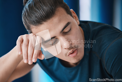 Image of Exercise, sweat and a tired sports man breathing in the gym after an intense or physical workout for health. Fitness, fatigue and a young male athlete or runner finished with his cardio training