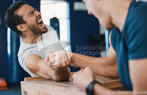 Image of Strong, loser or men arm wrestling at gym on a table in playful challenge together in fitness training. Game, pain or strong people in muscle power battle for sports, hard competition or tough match