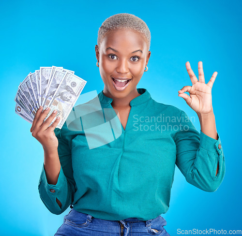 Image of Woman portrait, okay sign and money fan for bonus, financial success and winning, finance loan with wow. African person or winner surprise, yes and notes or cash profit on a studio, blue background