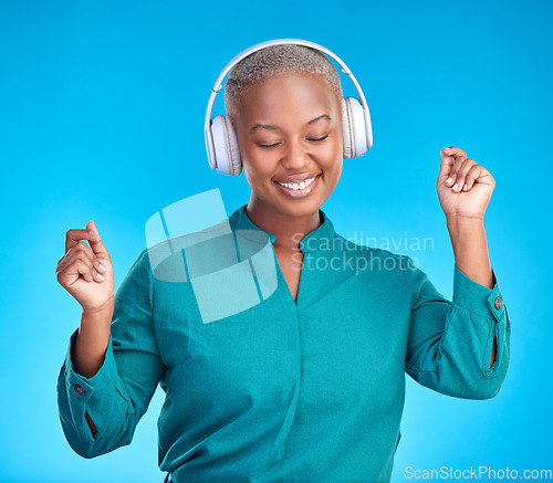Image of Black woman, headphones and studio with dancing, smile and listen to music by blue background. Young gen z student, sound tech and happy for audio streaming subscription, radio or excited with dance