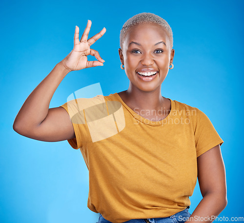 Image of Black woman, ok sign and smile in studio portrait for good review, vote and icon by blue background. African gen z girl, young student and hand for emoji, symbol and happy for feedback, like and yes