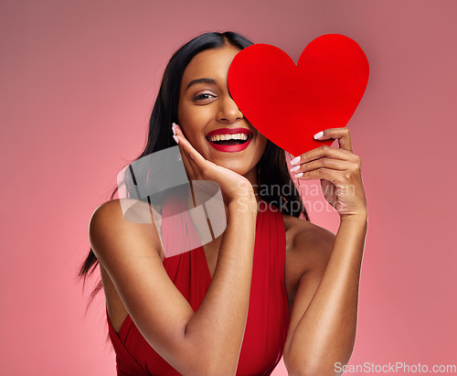 Image of Woman, paper heart and smile in studio portrait for makeup, beauty or romantic sign by red background. Happy girl, fashion model or cardboard emoji for love, cosmetic or happy for valentines day date