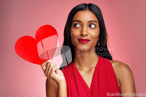 Image of Woman, paper heart and thinking in studio with makeup, beauty and romantic sign by red background. Young girl, ideas and cardboard emoji with love for cosmetics, valentines day date and aesthetic