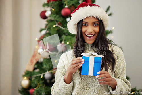 Image of Christmas, portrait or happy woman with a gift or box in present on a holiday celebration at home. Wonder, smile or excited Indian girl with present with giveaway prize package in a house in winter