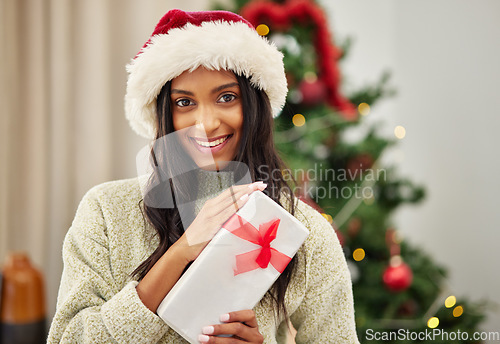 Image of Woman, Christmas present and smile in portrait, celebrate holiday with happiness and wrapped box with ribbon. Special event, female person at home with gift giving and package, festive and xmas