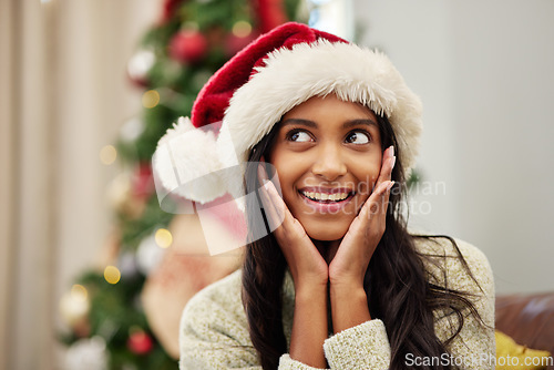 Image of Happy woman, face and thinking with Christmas hat by tree for festive season, celebration or gift surprise at home. Female person with smile in relax for holiday, weekend or December party in house