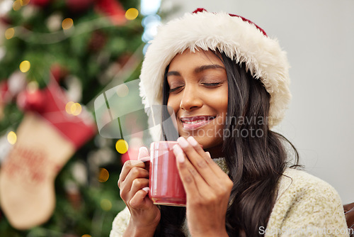 Image of Christmas, happy woman and coffee on home sofa with a smile while thinking of memory. Face of Indian female person with a hot chocolate or tea cup to relax for festive holiday, season or celebration