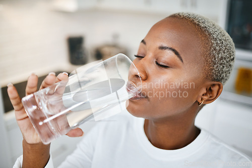 Image of Healthy, glass and woman drinking water for thirst, wellness and liquid nutrition at her home. Calm, energy and African female person enjoying cold health drink in the kitchen of her apartment.