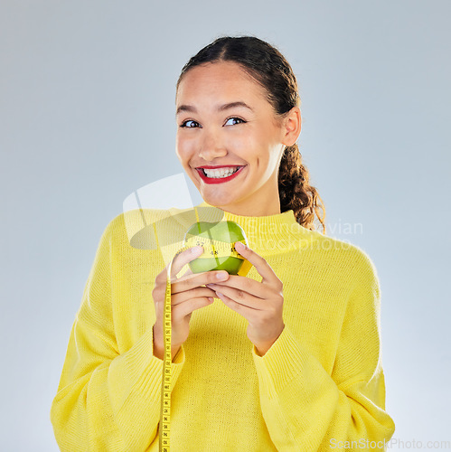 Image of Tape measure, apple and portrait of woman with fruit in studio for healthy eating, wellness and balance diet. Vegan, lose weight and female person on white background with food for nutrition or detox