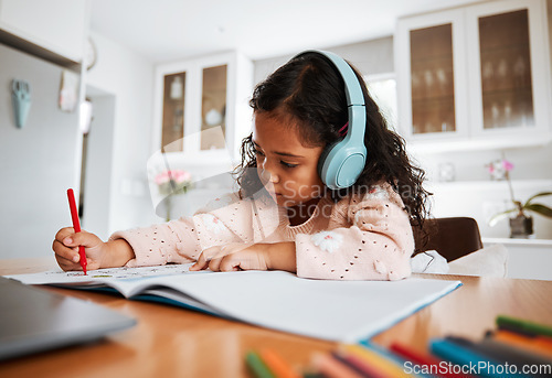 Image of Young child, learning and homeschool with headphones for homework, writing and drawing in books. Childhood development, focus and girl kid listening to audio while studying for kindergarten education