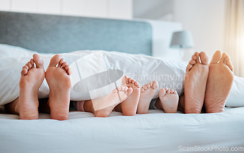 Image of Bed, feet and family together in the morning, sleeping or rest in bedroom on holiday, weekend or vacation. Mom, dad and children resting, dreaming or calm relaxing in home, house or hotel with kids