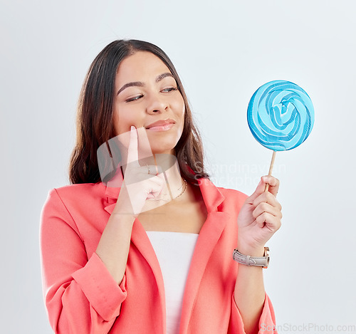 Image of Woman, face and thinking of lollipop, candy or sweets for junk food, snack or unhealthy decision. Curious, doubt or studio person wonder about sugar calories, choice or dessert on white background