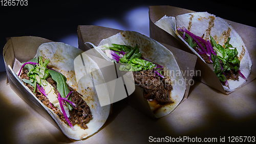 Image of Three pork carnitas street tacos in yellow corn tortilla.