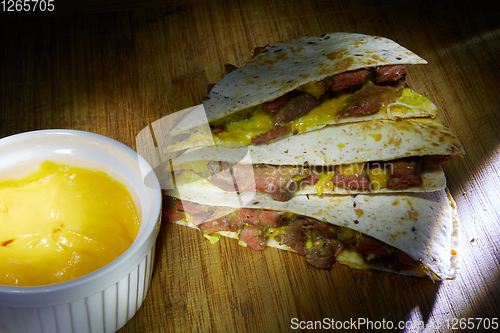 Image of Mexican quesadilla with chicken, cheese and peppers on wooden table