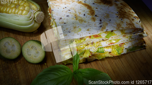 Image of Mexican quesadilla with chicken, cheese and peppers on wooden table