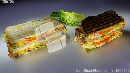 Image of Two sandwiches on black and white bread with beef and turkey