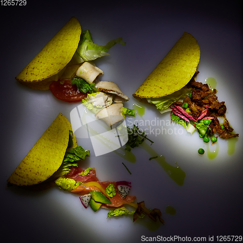 Image of Three different tacos with beef, chicken and salmon. View from above. With copy space.