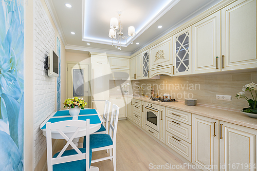 Image of Beige, white and cyan furniture at kitchen in provence style,