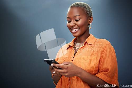 Image of Phone, texting and happy black woman in studio for social media, app or communication on grey background. Smartphone, search and African female smile for meme, post or online dating notification