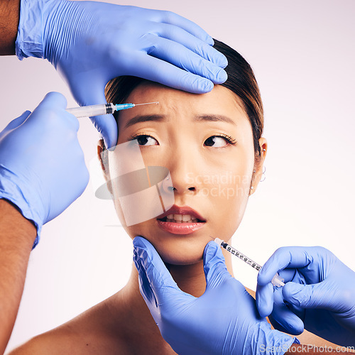 Image of Woman, needle and worry on face in studio for surgery, stress and thinking for cosmetic results by background. Japanese model, girl and syringe for lip filler, anxiety or transformation for aesthetic