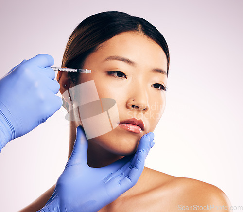 Image of Asian woman, beauty and needle for surgery in studio for cosmetics, eye filler or collagen by white background. Hands, doctor and syringe for patient, transformation or change with collagen in face