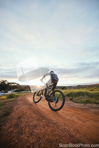 Image of Sports, cycling and man on bicycle in countryside for training, workout and exercise in nature. Fitness, cyclist and person with mountain bike for adventure, freedom and ride on outdoor dirt road