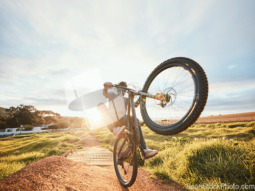 Image of Sports, cycling trick and man on bicycle in nature for training, workout and exercise in countryside. Fitness, morning and cyclist on mountain bike for adventure, freedom and adrenaline on dirt road