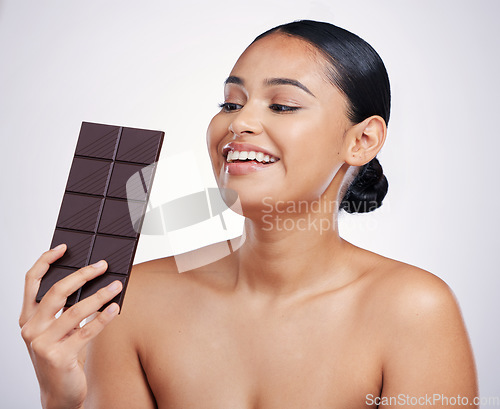 Image of Chocolate, happy and face of woman in studio with luxury food, sweet treats and candy on white background. Wellness, calories and excited female person holding cocoa bar, sugar snack and dessert slab