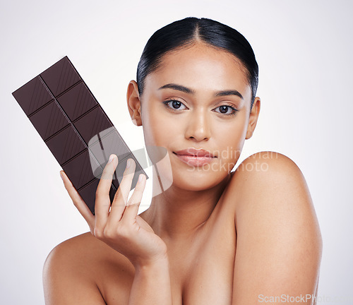 Image of Chocolate, dessert and portrait of woman in studio with luxury food, sweet treats and candy. Wellness, calories and face of female person holding cocoa bar, sugar snack and slab on white background