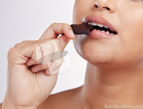 Image of Chocolate, bite and mouth of woman with sweets in studio eating luxury food, treats and candy. Sugar, calories and face closeup of female person with cocoa bar, dessert and snack on white background