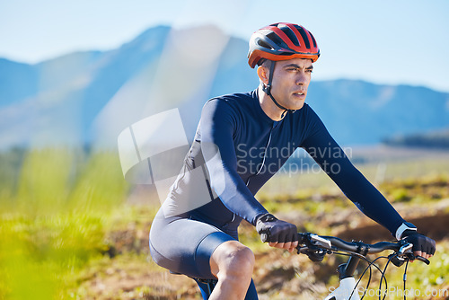 Image of Fitness, countryside or man cycling on a mountain bike for training, cardio workout or exercise outdoors. Serious, healthy biker or sports athlete riding a bike on a path for wellness or challenge