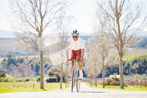 Image of Sports, cycling and man on a bike in a park for fitness, training or morning cardio routine in nature. Bicycle, exercise and male cyclist riding on path for practice, freedom or performance challenge