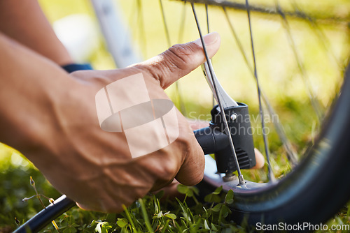 Image of Fixing, bicycle and a man with air in wheel for maintenance, safety or repair while cycling. Bike, hands and a sports person or athlete with a pump or tools for flat tire or broken transportation