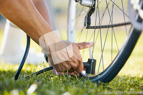 Image of Air, bicycle and a man fixing wheel outdoor with pump or tools while cycling in nature. Bike, hands and a sports person or athlete with flat tire and maintenance, safety or repair on transportation