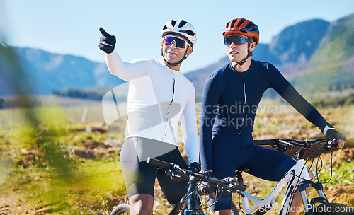 Image of Exercise, bike and pointing with friends in nature for cycling, taking a break from a cardio or endurance workout. Fitness, mountain or countryside view with a man cyclist team training for sports