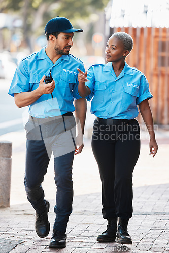 Image of Security guard, safety officer and team walking on street for protection, patrol or watch. Law enforcement, talking and duty with a crime prevention man and black woman in uniform outdoor in the city