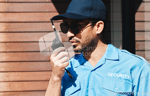 Image of Security guard, walkie talkie and safety officer man outdoor for protection, patrol and communication. Law enforcement, serious and crime prevention worker with sunglasses, uniform and radio in city