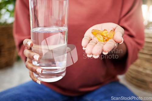 Image of Hand of woman, water and supplement pills for health, diet and commitment to nutrition or natural wellness product. Hands of girl with multivitamin tablet, drink in glass and organic healthcare drugs