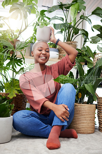 Image of Portrait of a black woman, garden and happy with plant on head and care for plants, leaves and sunshine in greenhouse. Gardening, growth and person with pride for houseplant, cactus or aloe vera