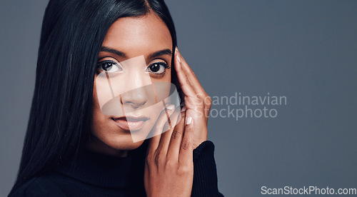 Image of Face, skincare touch and confidence of woman in studio isolated on a gray background mockup space. Serious portrait, natural beauty and cosmetics of Indian model with facial treatment for aesthetic.