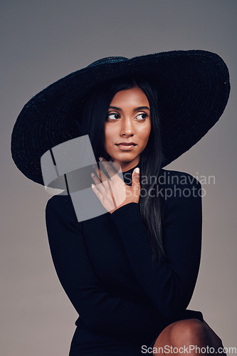 Image of Fashion, beauty and woman in vintage hat and person thinking about event or designer clothing on show in studio background. Indian model, retro style and idea for luxury clothes or accessories