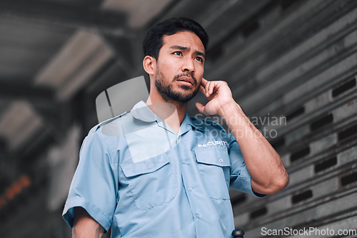 Image of Security guard, serious and safety officer man on the street for protection, patrol or watch. Law enforcement, focus and duty with a crime prevention male worker in uniform to listen communication