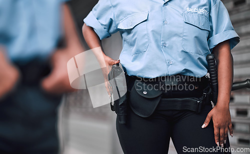 Image of Hand, gun and security with a guard on duty or patrol in the city for safety and law enforcement. Police, service and armed response with an officer outdoor in an urban town for crime prevention