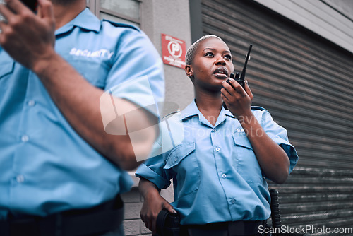 Image of Security, walkie talkie and a black woman police officer in the city during her patrol for safety or law enforcement. Radio, communication and service with a female guard on a street in an urban town
