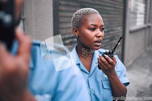 Image of Security, walkie talkie and a police woman in the city during her patrol for safety or law enforcement. Radio, communication and service with an african female guard on a street in an urban town