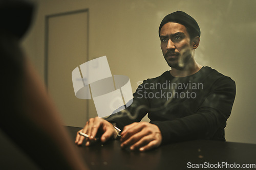 Image of Man in investigation, smoking and detective in interrogation room with criminal, suspect or interview with a gangster. Police officer, questioning and statement of truth and person with cigarette