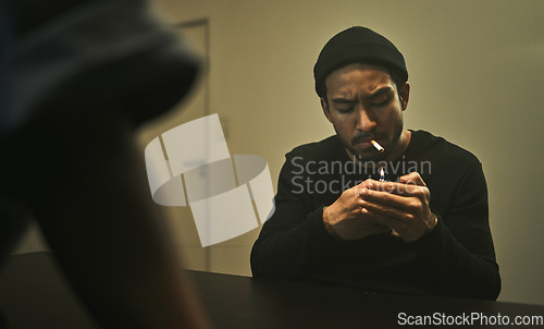 Image of Man, smoking and talking to police detective in interrogation room with criminal, suspect or interview with a gangster. Security, officer and questioning a person in conversation and investigation