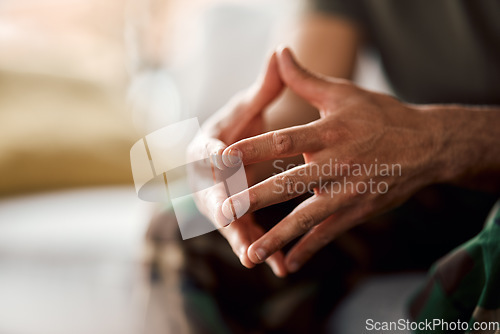 Image of Hands clasped, soldier sitting and military person with anxiety, depression or problem on sofa. Army man, couch and ptsd, stress and crisis after war, trauma and waiting in living room alone in home