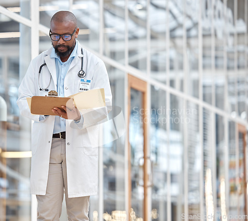 Image of Black man, doctor and reading notes on clipboard with research documents, healthcare schedule or test results in hospital. Male medical worker, walking and planning report of insurance info in clinic