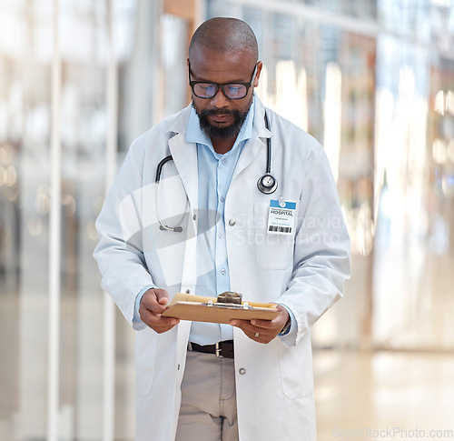 Image of Black man, doctor and reading clipboard with documents of research, healthcare schedule and test results in hospital. Male medical worker with report of insurance, notes and planning info in clinic